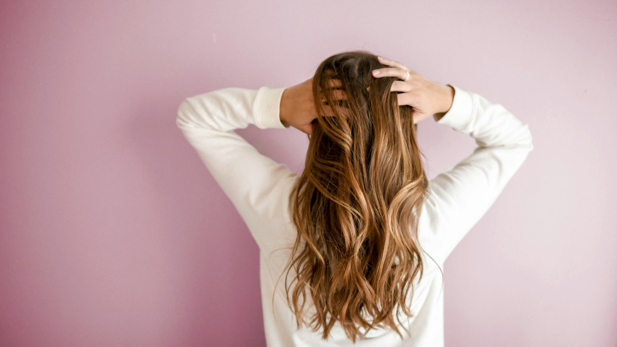 une femme passe ses mains dans ses cheveux